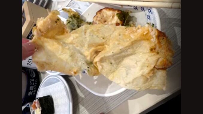 Papel absorbente frito por error en un plato de tempura servido en un Hamazushi