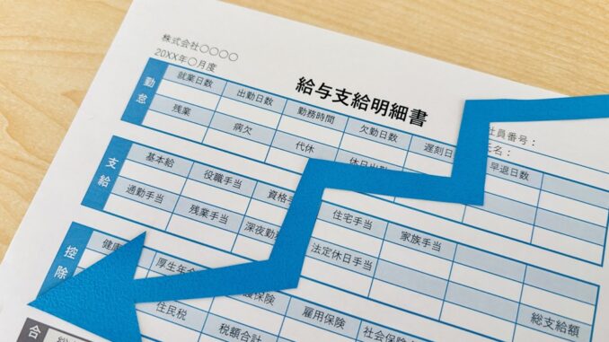 Recibo de salario con flecha descendente reflejo de la caída del salario real en Japón.