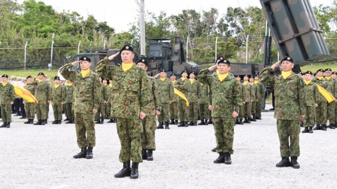 Militares japoneses forman delante de un lanzamisiles en una isla de Okinawa